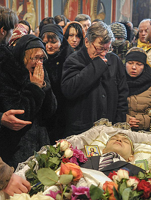 Parentes e amigos participam do velório de Mikhail Zhiznevsky, morto durante protestos contra o governo na Ucrânia 