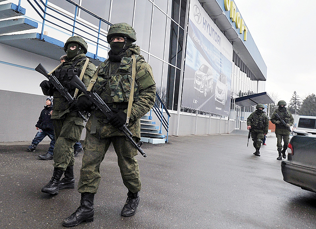 Homens armados no identificados patrulham aeroporto de Simferopol, na Crimeia, invadido nesta sexta