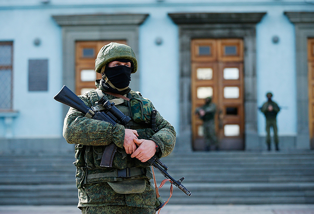 Homem armado patrulha prdio da administrao regional da Crimeia, em Simferopol