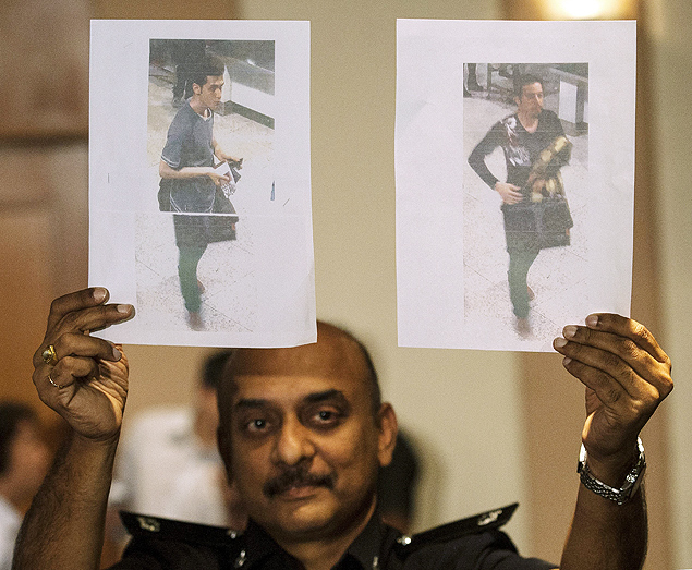 Policial da Malsia mostra fotos dos dois iranianos que viajaram com passaportes europeus roubados no avio desaparecido
