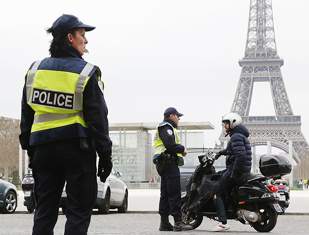 Policial faz controle de veculos em frente  torre Eiffel em Paris; rodzio de veculos voltou aps alta poluio