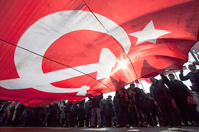Membros do Partido Comunista agitam bandeira em ato a favor da anexação da Crimeia em Moscou