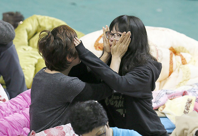Familiares das vtimas de naufrgio se consolam em ginsio de esportes em Jindo, na Coreia do Sul