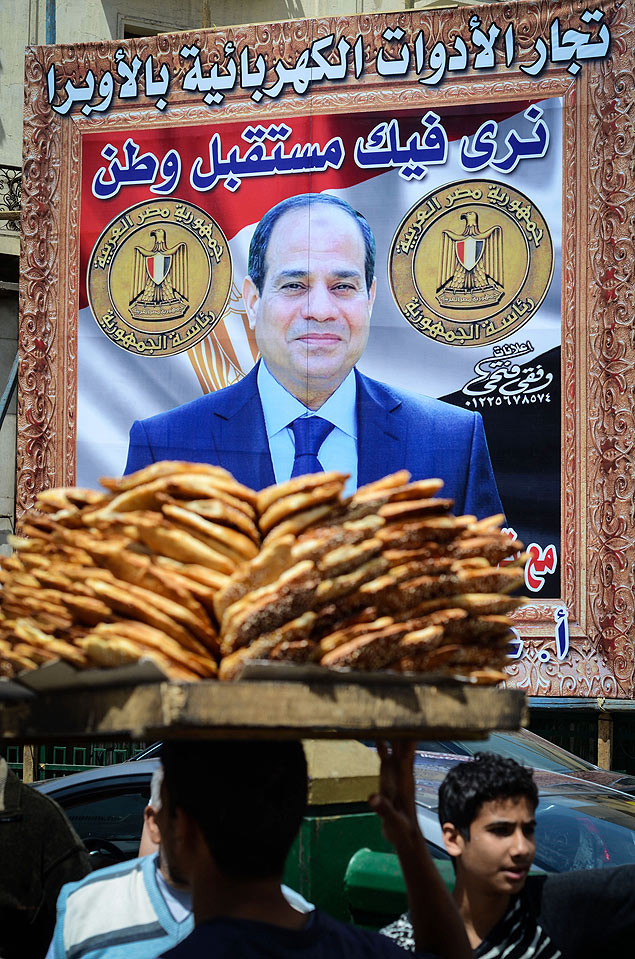 No Cairo, egpcios caminham diante de pster do general Abdel Fattah al-Sisi, candidato nas eleies presidenciais deste ms