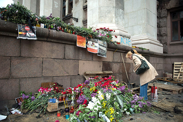 Mulher coloca flores do lado de fora de prdio que pegou fogo em Odessa, na Ucrnia