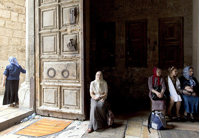 Peregrinas crists sentam na entrada da Igreja do Santo Sepulcro, em Jerusalm