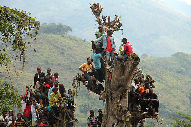 Meninos observam guerrilheiros de Ruanda entregando suas armas em Kigogo, no Congo