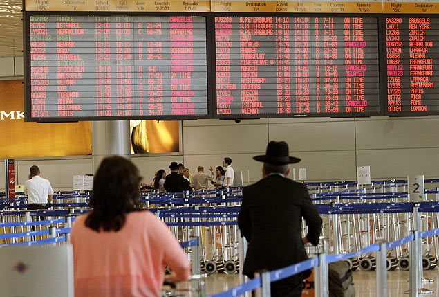 Passageiros embarcam no aeroporto de Tel Aviv, um dia aps incio da suspenso de voos a Israel