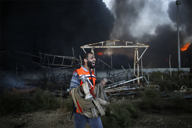 Homem trabalha para apagar incndio que deixou a nica central eltrica de Gaza fora de funcionamento aps bombardeio israelense