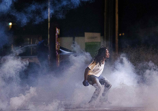 Manifestante grita contra a polcia em meio a nuvem de bomba de gs em mais uma noite de protestos contra morte de jovem negro pela polcia 