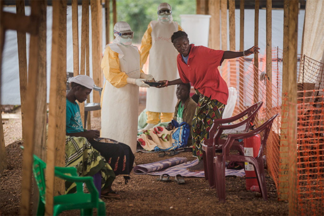 Com traje especial de proteção, equipe serve refeição a pacientes infectados com ebola em hospital em Kailahun, no leste de Serra Leoa (África) 