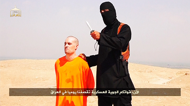 Un militante enmascarado del Estado Islmico habla con un cuchillo en la mano cerca del periodista norteamericano James Foley 