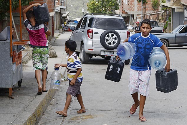 Sob racionamento, crianas levam gales d'gua para encher longe de casa, em Caracas
