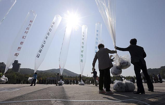 Pessoas amarram panfletos em bales para serem lanados para Coreia do Norte