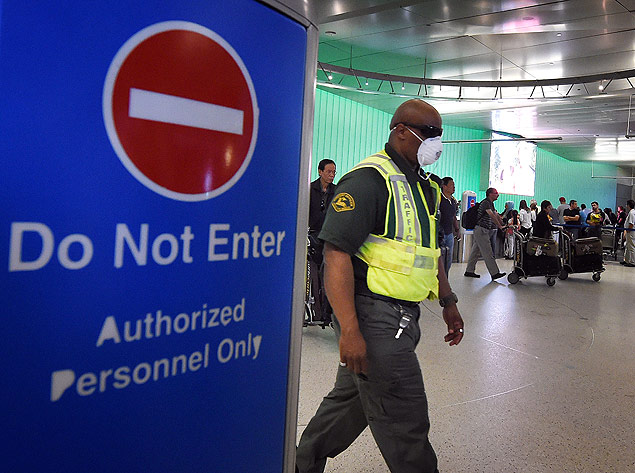 Um funcionrio do aeroporto de Los Angeles usa mscara de proteo no rosto