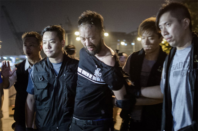 Com camiseta do Corinthians, ativista pr-democracia  detido por policiais durante ato prximo da sede do governo em Hong Kong