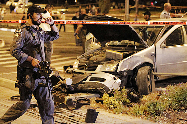 Policial israelense em frente ao carro que atingiu uma parada de metr de superfcie em Jerusalm