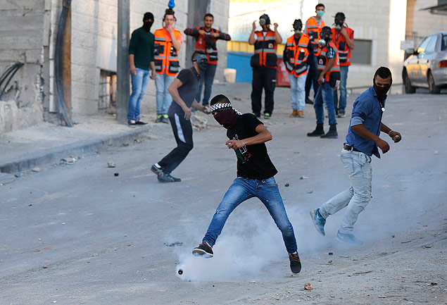 Manifestante palestino chuta bomba de gs lanada por soldado israelense em Jerusalm Oriental