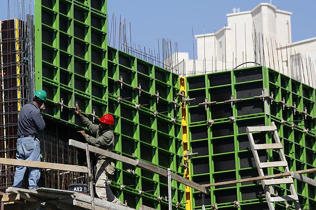 Palestinos trabalham na construo de novo projeto de habitao em bairro anexado de Jerusalm Oriental