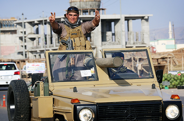 Combatente peshmerga faz o sinal da vitria enquanto se dirige a Kobani para combater o EI 