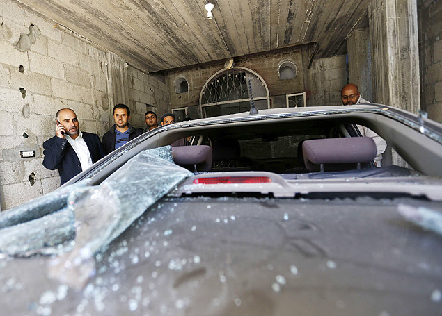 Fayez Abu Eitta (E), lder do Fatah em Gaza, fala ao celular perto de carro danificado em ataque