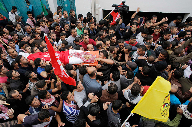 Palestinos do campo de refugiados de Arroub carregam corpo de jovem morto em confrontos com Israel