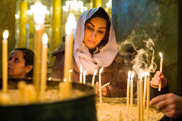 Mulher acende vela durante missa em catedral de Istambul, Turquia