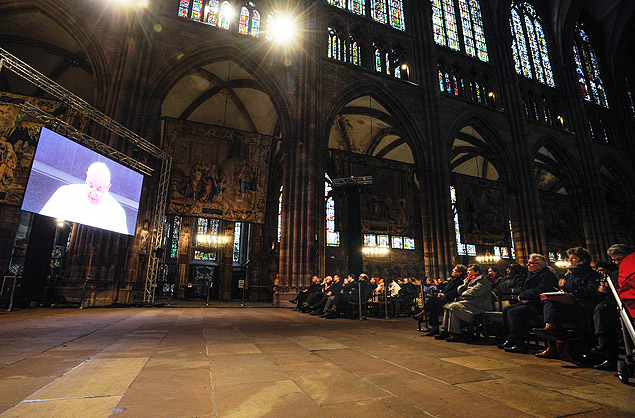 Catlicos assistem ao discurso do papa por um telo na catedral de Estrasburgo, Frana 