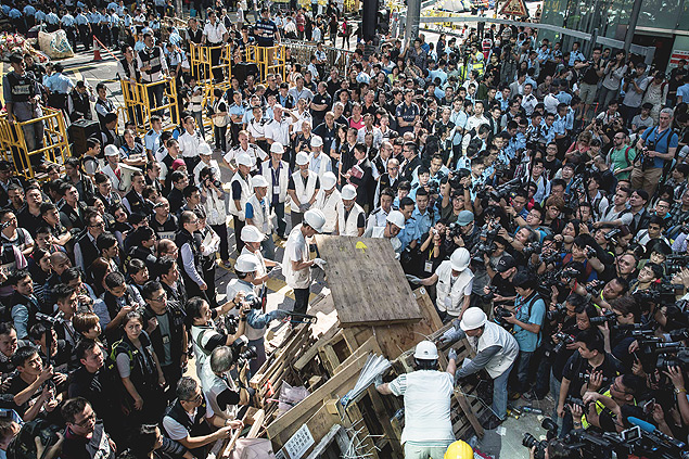 Jornalistas cercam funcionrios que retiram barricadas em Mongkok, Hong Kong