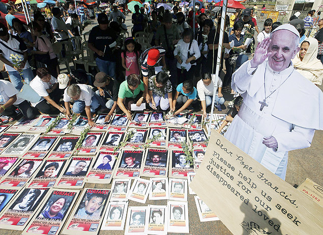 Filipinos acendem velas para desaparecidos do lado de fora de igreja em Manila