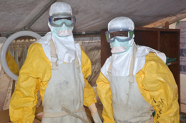 Trabalhadores de sade usam roupa de proteo contra ebola em Conacri, capital da Guin