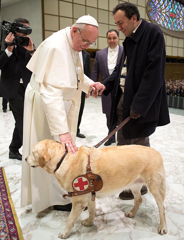 Papa Francisco faz carinho em cão-guia durante evento no Vaticano, em 2013