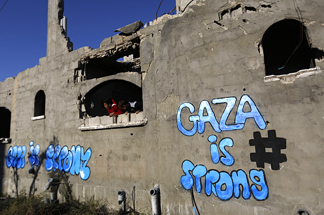 Crianas em casa atingida nos confrontos com Israel na Cidade de Gaza; na inscrio, "Gaza  forte"