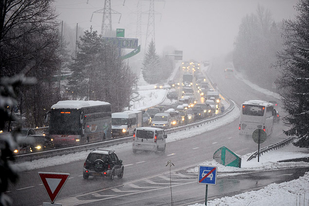 Traffic bound for French Alpine ski resorts moves slowly along the highway in the direction of Motiers from Albertville early on December 28, 2014. Heavy snowfall in the French Alps left some 15,000 drivers stranded overnight, forcing many to pass the night in their cars and prompting officials to open emergency shelters. The snow and ice hit as a rush of holidaymakers were heading to and leaving from ski resorts in the Savoie region in southeastern France, where authorities set up shelters in at least 12 towns. AFP PHOTO / Jean-Pierre Clatot ORG XMIT: 1212