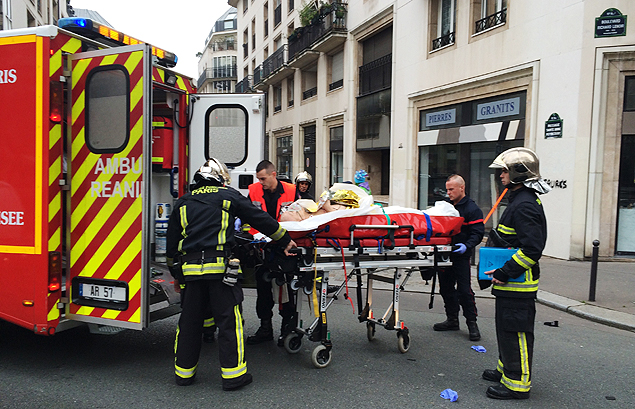 Bombeiros carregam homem ferido aps ataque a jornal satrico "Charlie Hebdo", em Paris