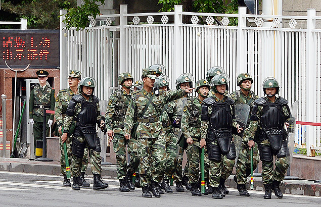 Paramilitares chineses patrulham rua em Urumqi, capital de Xinjiang, regio onde vive a minoria uigur 