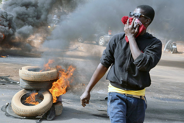 Manifestante queima pneus durante onda de protestos que já deixou dez mortos e destruiu símbolos cristãos no Níger