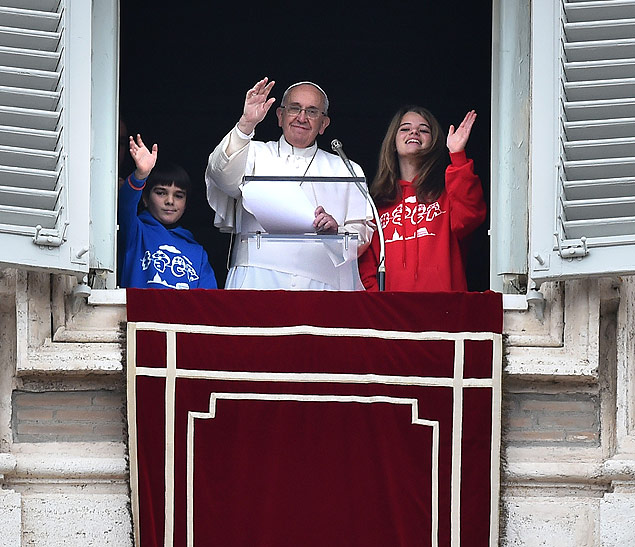 Com duas crianas, papa Francisco acena durante a orao do ngelus deste domingo (25)