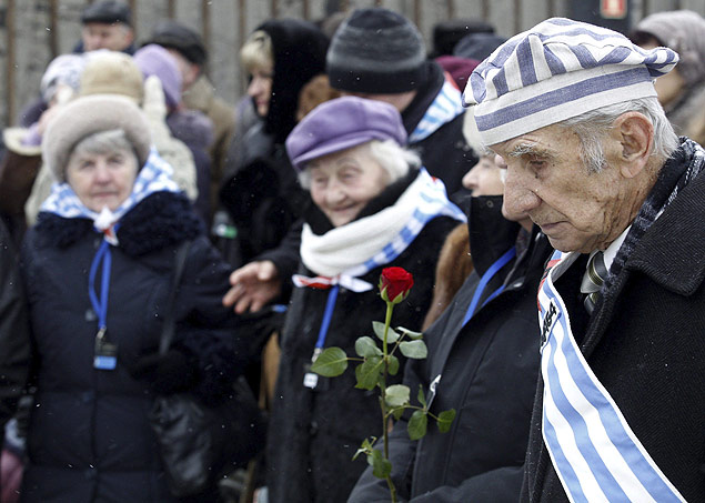Sobreviventes de Auschwitz depositam flores perante o "Muro da Morte" em Auschwitz