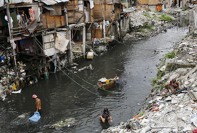 Moradores cruzam crrego em favela de Manila, nas Filipinas