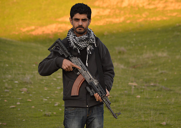 O iraquiano curdo Shvan Rasool, que vive em Bardarash, no norte do Iraque, empunha sua AK-47
