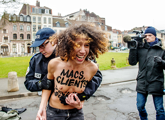 Policial detm ativista do Femen aps protesto na chegada de Dominique Strauss-Kahn ao tribunal