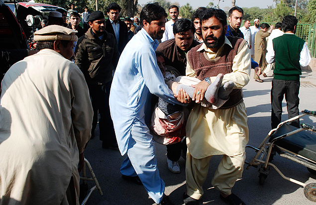 Fiis carregam corpo de um homem morto aps ataque a mesquita xiita em Peshawar, no Paquisto