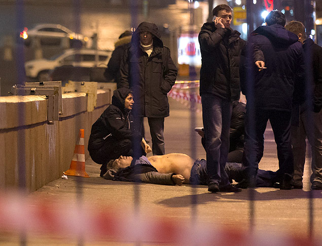 Russian police investigate the the body of Boris Nemtsov, a former Russian deputy prime minister and opposition leader at Red Square with St. Basil Cathidral in the background in Moscow, Russia, Saturday, Feb. 28, 2015. Russia's Interior Ministry says Boris Nemtsov, a leading opposition figure and former deputy prime minister, has been shot and killed near the Kremlin. Nemtsov, a sharp critic of President Vladimir Putin, was killed early Saturday. His death comes just a day before a major opposition rally in Moscow. (AP Photo/Pavel Golovkin) ORG XMIT: XAZ116