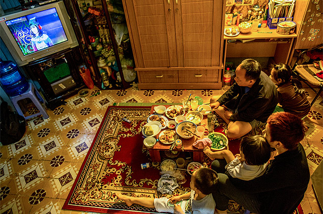 Nguyen Ba Tien e sua família assistem a programa satírico que passa anualmente na TV no Vietnã