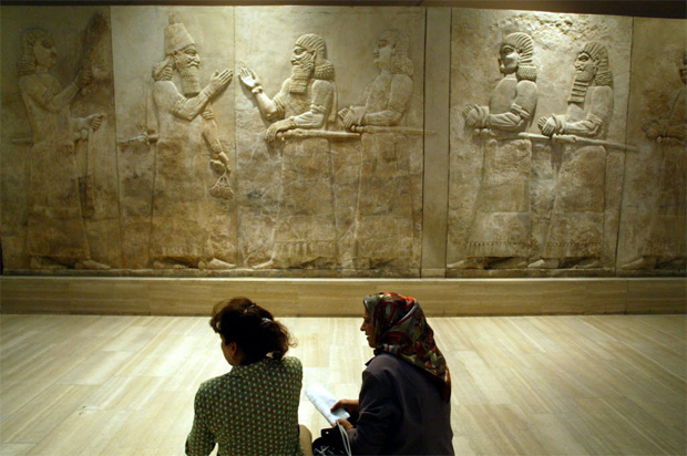 Mulheres observam em museu em Bagd mural retirado do stio arqueolgico assrio de Nimrud