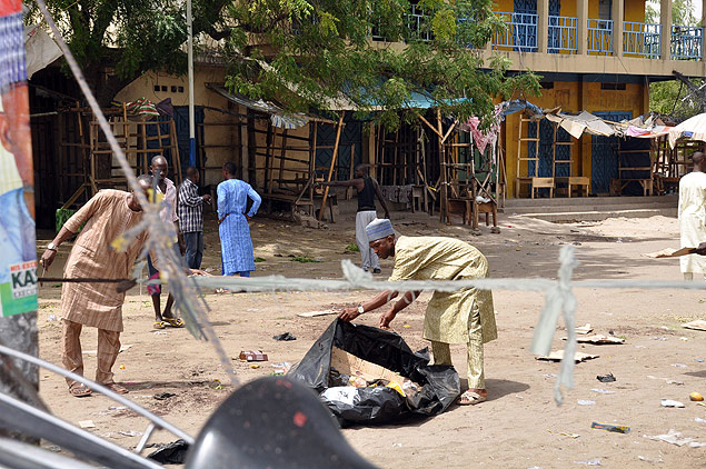 Homem tenta reunir vestgios de uma das cinco exploses ocorridas em Maidguri, na Nigria, neste sbado (7)