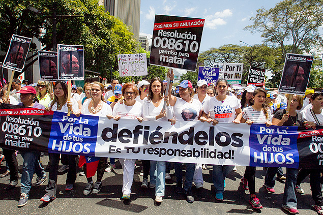 Deputada cassada María Corina Machado (centro) lidera marcha em Caracas no domingo