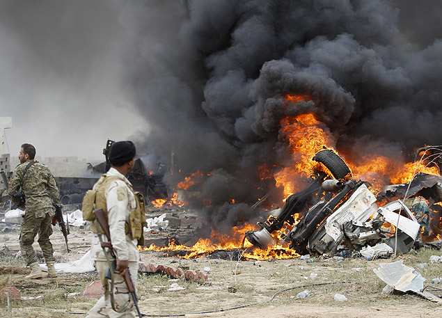 Militantes xiitas tentam apagar incndio em carros atingidos por exploso do Estado Islmico em Tikrit