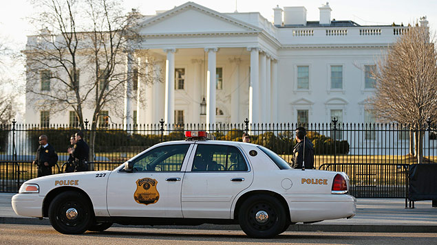 Members of the U.S. Secret Service keep watch at the fence surrounding the White House in Washington March 12, 2015. The U.S. Secret Service said on Wednesday that two agents were under investigation after an incident last week in which they were reported to have driven a government car into White House barricades after drinking at a late-night party. REUTERS/Kevin Lamarque (UNITED STATES - Tags: POLITICS CRIME LAW) ORG XMIT: WASW204